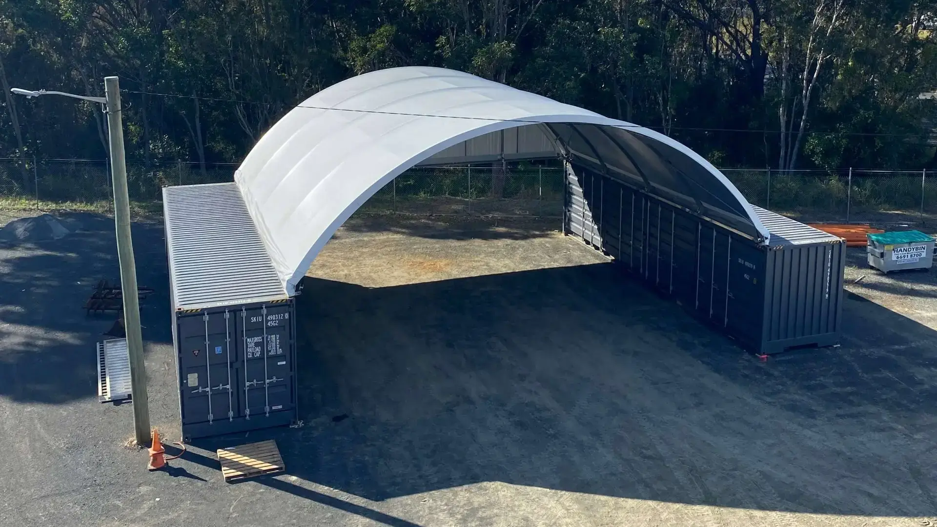 a container dome with two blue shipping containers which is used for storage